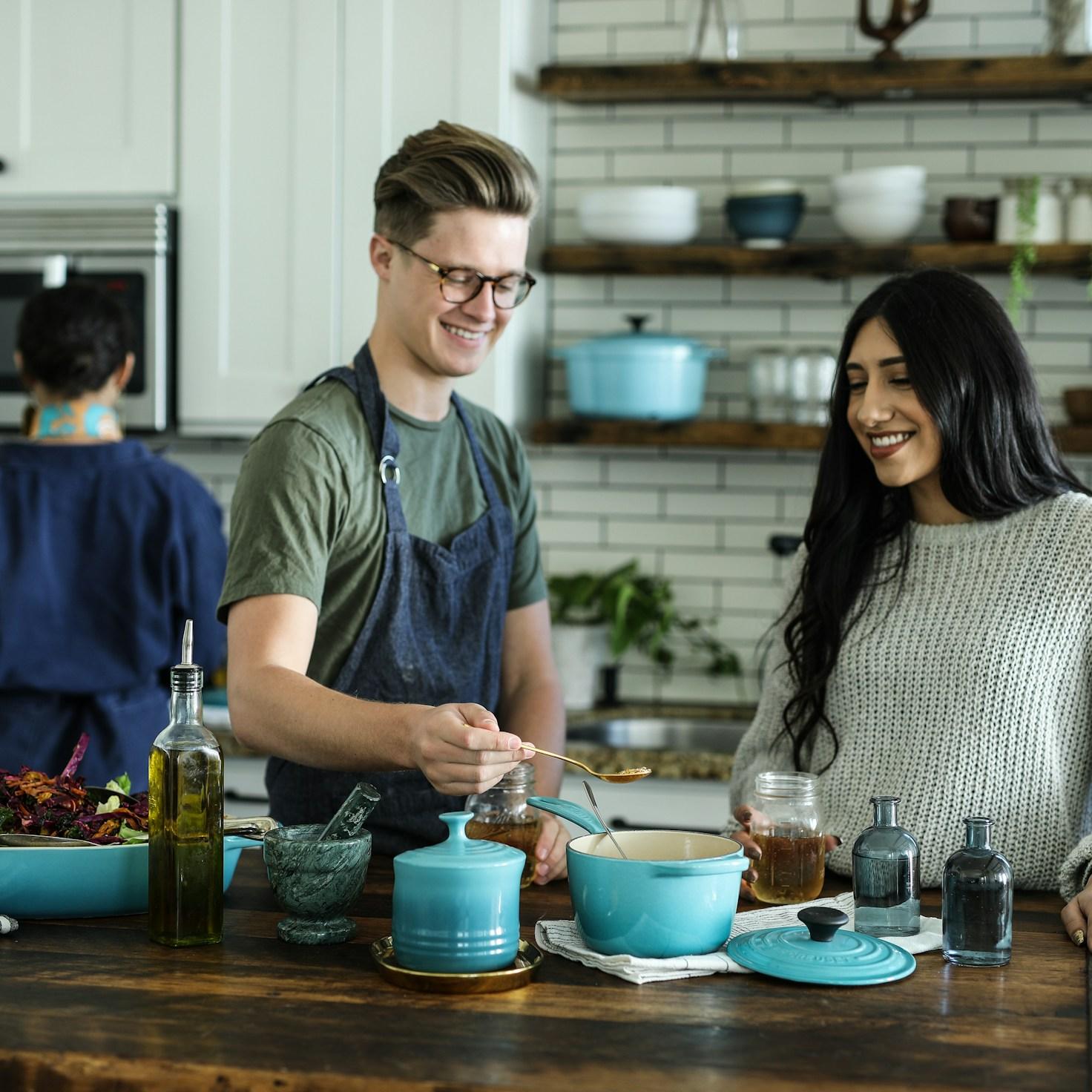 Community members cooking together in a modern kitchen, sharing recipes and techniques